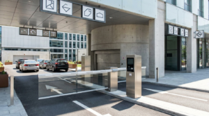 Entrada de estacionamento rotativo comercial com cancela automática e totem de tickets