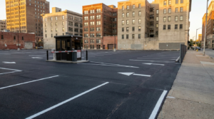 Terreno urbano convertido em estacionamento pavimentado com vagas demarcadas e guarita